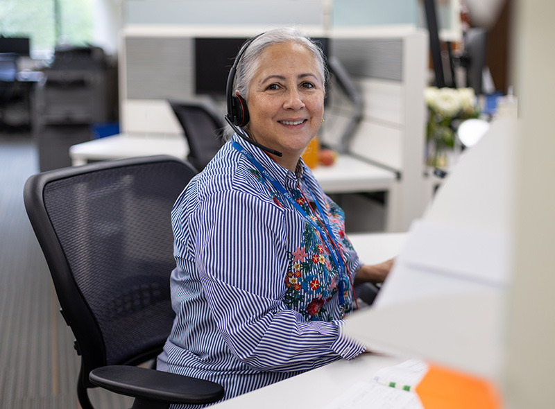 employee in blue striped shirt smiling toward viewer