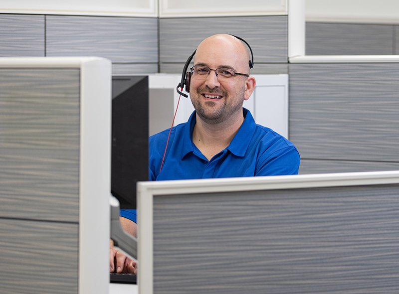 PCI employee wearing glasses and a headset