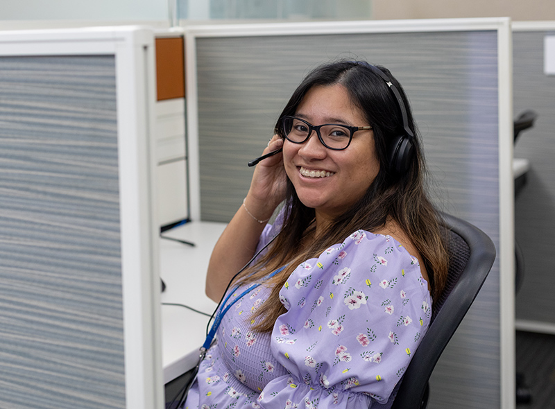 PCI employee wearing lilac shirt and black headset